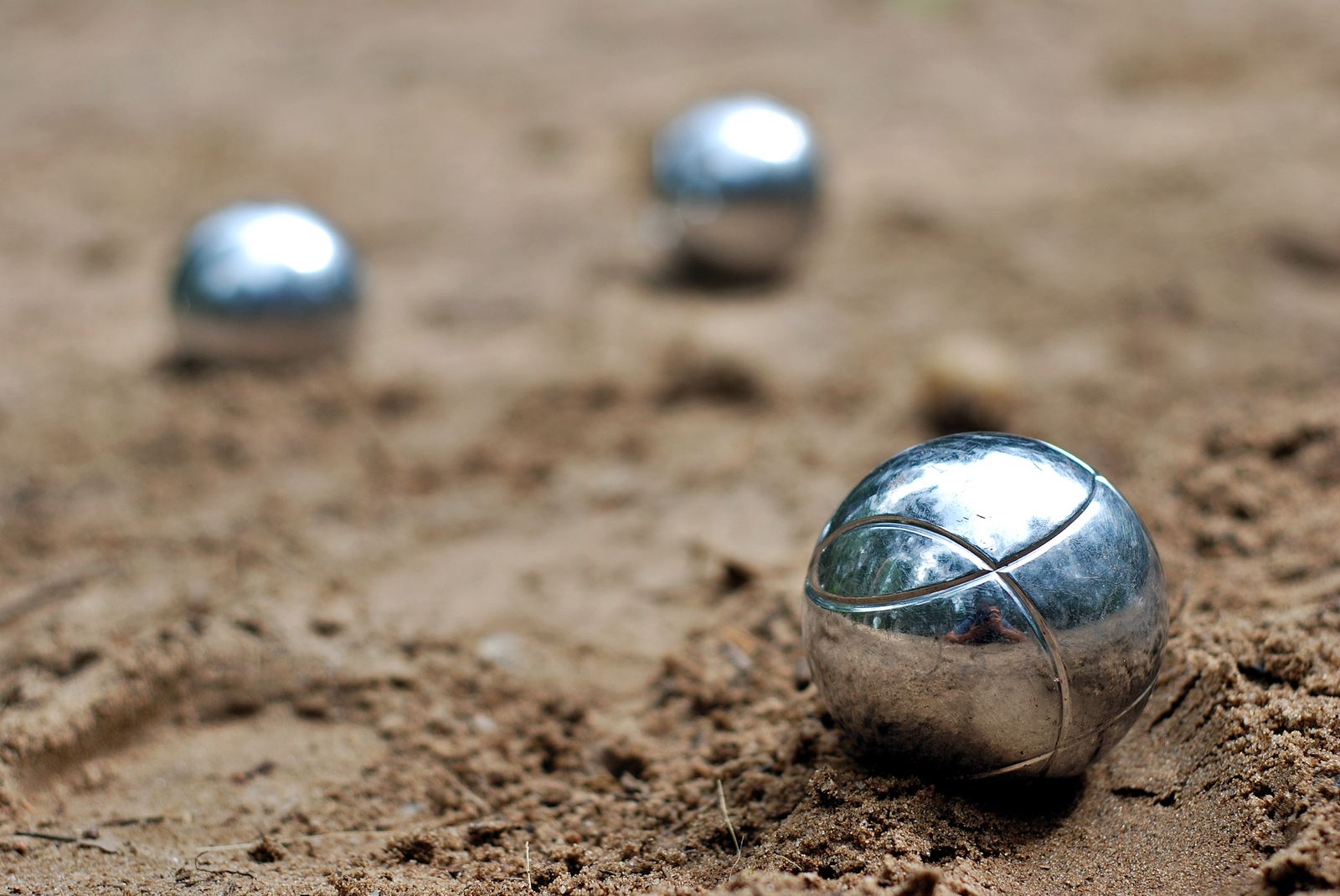 ISE Travel Pétanque Thailand tour — players competing on a riverside sand court in Kanchanaburi at golden hour