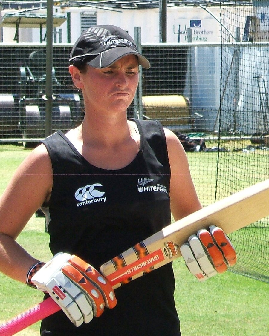 Katey Martin in New Zealand kit holding a cricket bat in the nets
